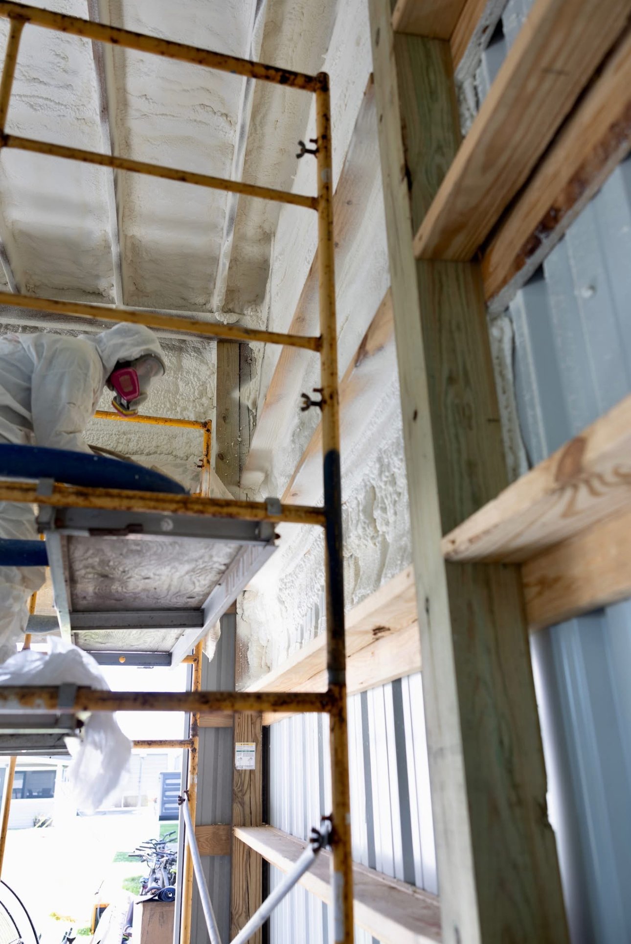 Bayou Spray Foam technician on scaffolding spraying foam insulation South Louisiana